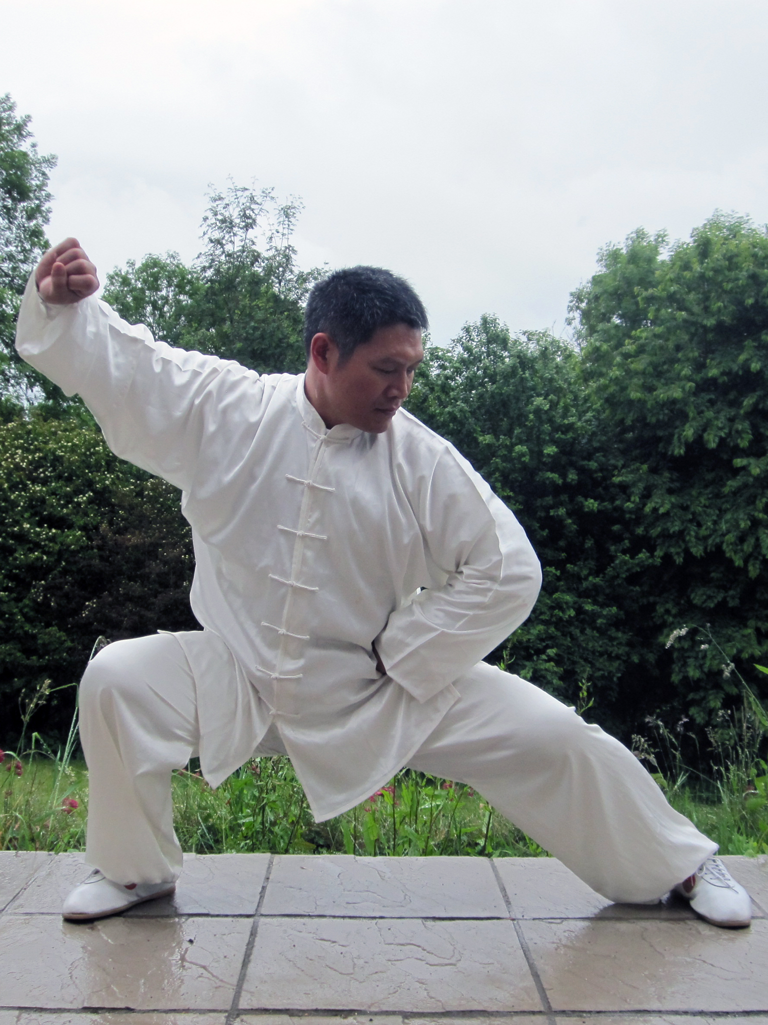 Shifu Liu performing tai chi outdoors on a patio