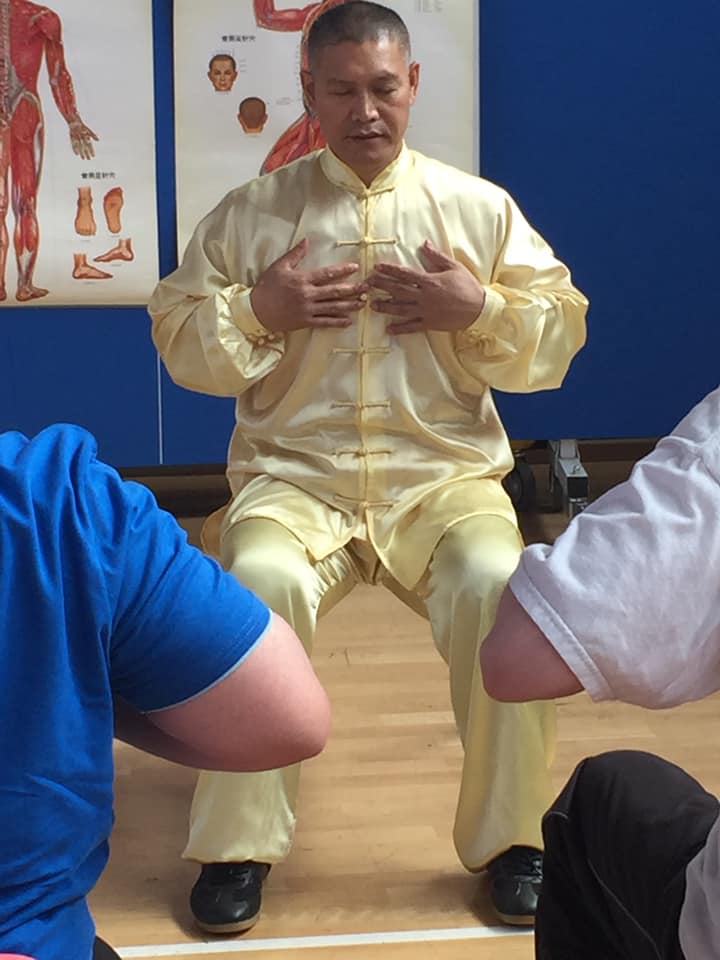 Shifu Liu in gold uniform teaching Traditional Chinese Medicine