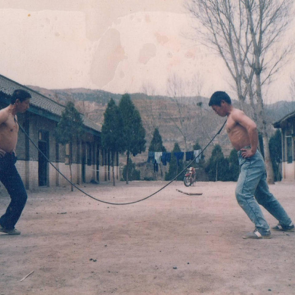 Vintage photo of two men demonstrating steel jacket training with chain